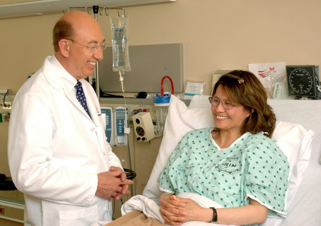 A smiling patient recovering in a hospital bed after undergoing successful robotic surgery.